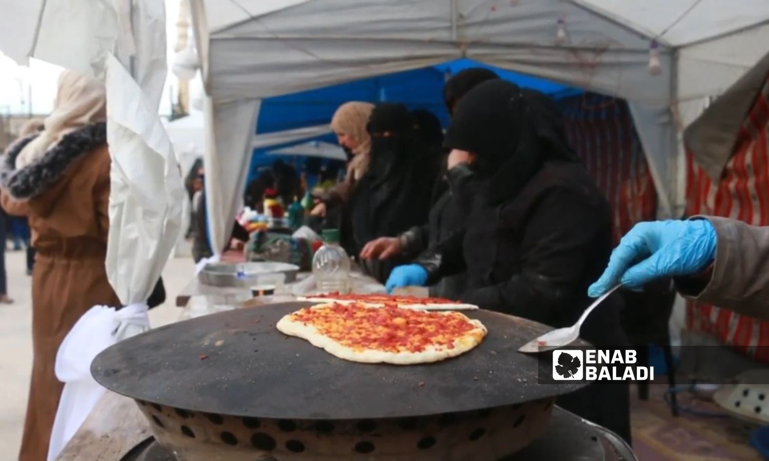 Syrian women prepare saj bread for sale in the city of Azaz in the northern Aleppo countryside – December 2023 (Enab Baladi)