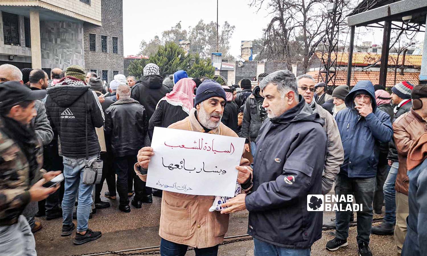 Protesters stand in front of the Water Establishment in As-Suwayda, demanding political change in Syria - February 19, 2024 (Enab Baladi)
