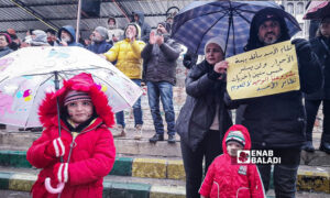 A family in Al-Karama Square in the center of As-Suwayda governorate protesting to demand political change in Syria - January 26, 2024 (Enab Baladi)