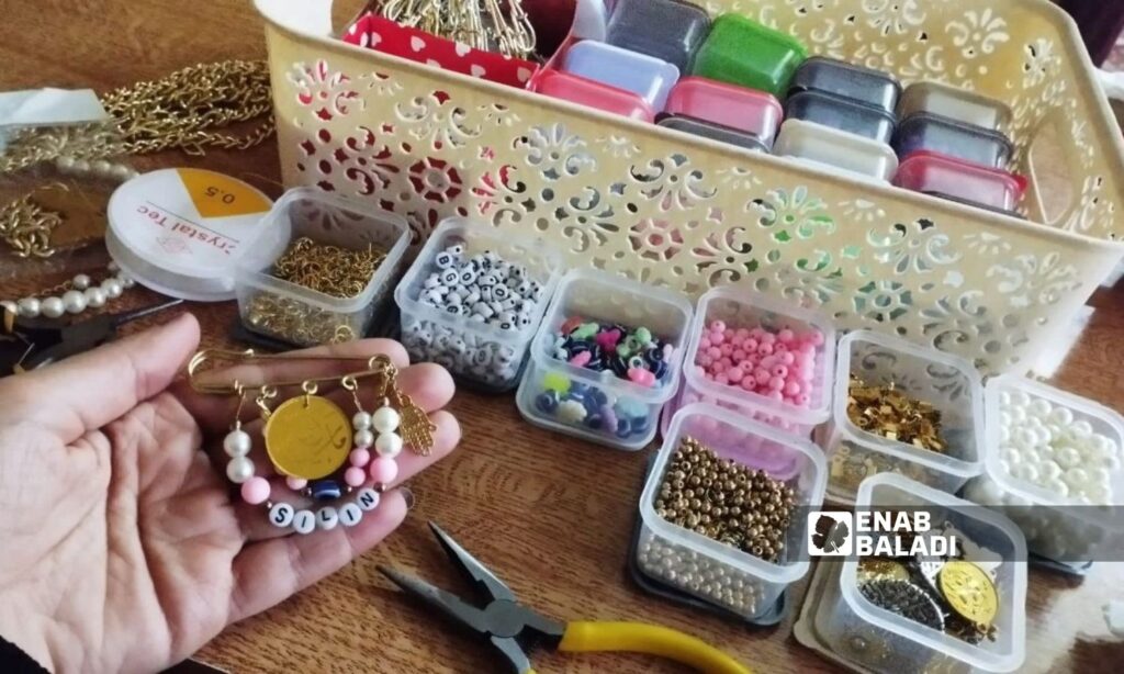 A woman makes accessories at her home in the city of Douma, Damascus countryside - February 2024 (Enab Baladi/Sarah al-Ahmad)