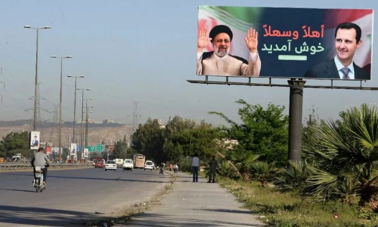 A billboard including pictures of Iranian President Ebrahim Raisi and the head of the Syrian regime, Bashar al-Assad, in Damascus during the Iranian president's visit - May 2023 (AFP)