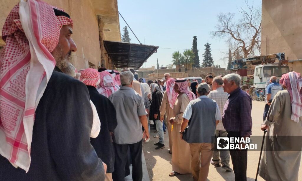 A group of retired employees line up to receive their salaries at the Qamishli post office - February 22, 2024 (Enab Baladi/Majd al-Salem)