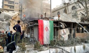 The Iranian flag and a picture of Qassem Soleimani in front of the rubble of the Iranian consulate in Damascus - April 1, 2024 (Reuters)
