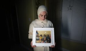 Mariam Kam Almaz holds a photo of her father, US doctor Majd Kam Almaz with some of his grandchildren - May 17, 2024 (Associated Press)