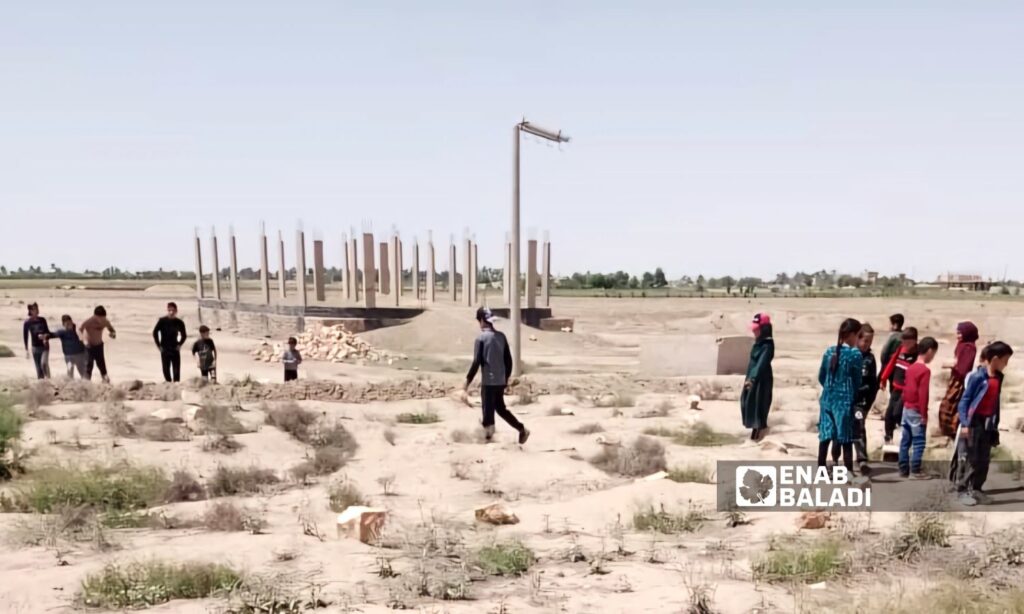 Children in the town of al-Baghouz in the eastern countryside of Deir Ezzor passing over the remains of one of the mass graves - April 23, 2024 (Enab Baladi/Obadah al-Sheikh)