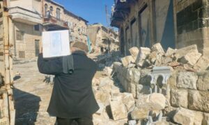 A man carries World Food Programme aid to his home in Idlib, northwest Syria, days after the earthquake disaster - February 27, 2023 (WFP)