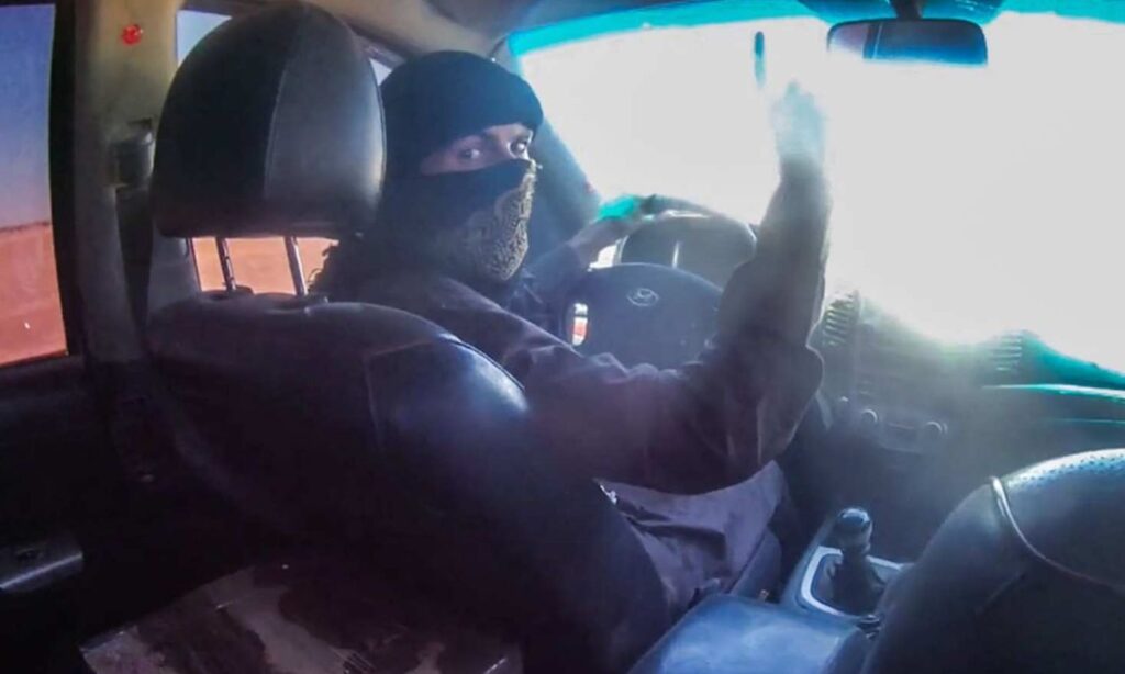 A fighter from the Islamic State organization before detonating a car he was driving inside an SDF military headquarters in eastern Deir Ezzor province – June 3, 2024 (Amaq Agency)