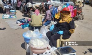 A woman sells strained yogurt in a popular market in the city of Tafas - April 1, 2024 (Enab Baladi/Halim Muhammad)