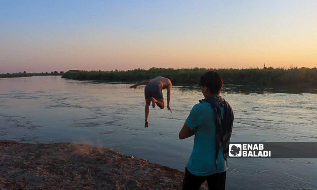 Young men swim in the Euphrates River in the countryside of Deir Ezzor, eastern Syria - July 20, 2024 (Enab Baladi/Obadah al-Sheikh)