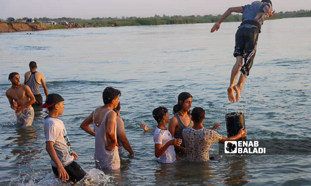 Young men swim in the Euphrates River in the countryside of Deir Ezzor, eastern Syria - July 20, 2024 (Enab Baladi/Obadah al-Sheikh)