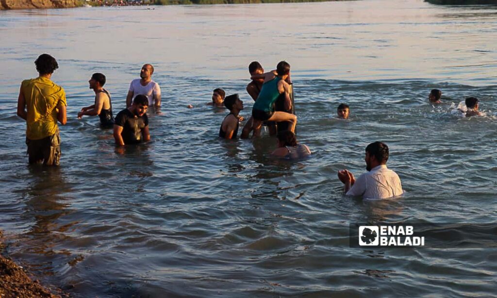 Young men swim in the Euphrates River in the countryside of Deir Ezzor, eastern Syria - July 20, 2024 (Enab Baladi/Obadah al-Sheikh)