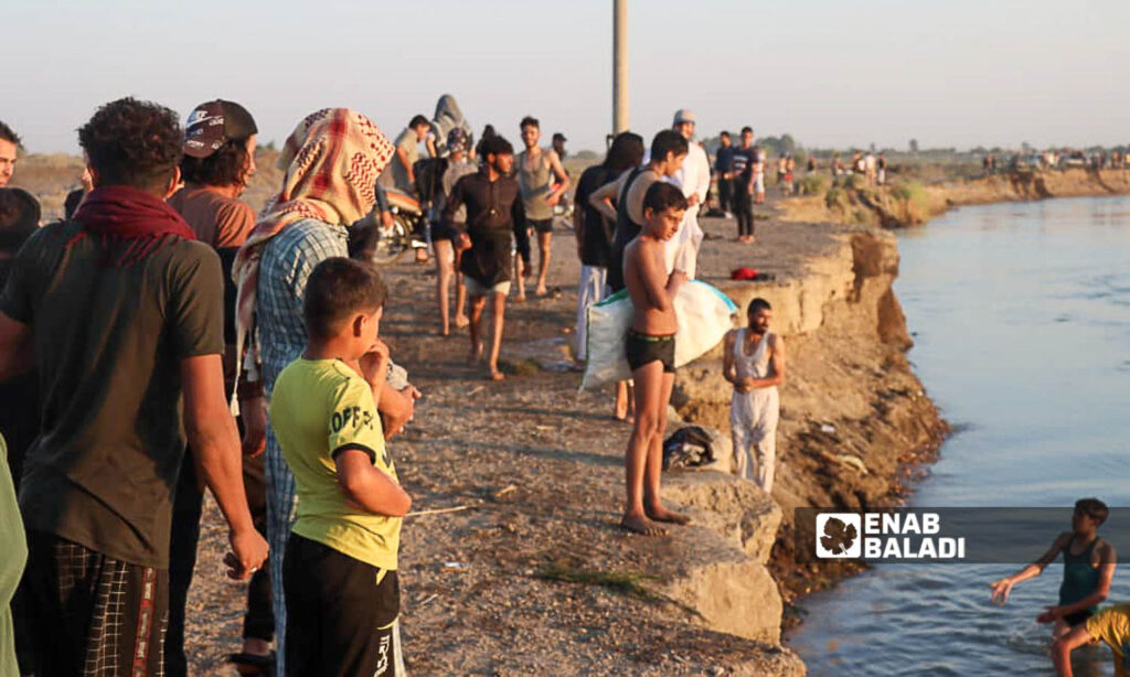 Young men on the banks of the Euphrates River in the area of al-Busayrah in the countryside of Deir Ezzor, eastern Syria - July 20, 2024 (Enab Baladi/Obadah al-Sheikh)