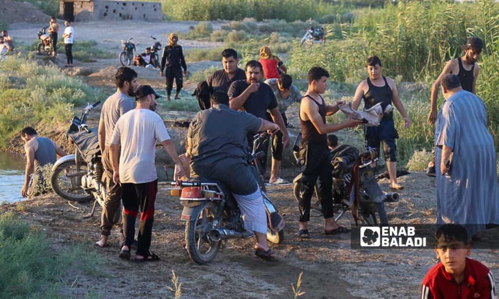 Young men on the banks of the Euphrates River in the area of al-Busayrah in the countryside of Deir Ezzor, eastern Syria - July 20, 2024 (Enab Baladi/Obadah al-Sheikh)