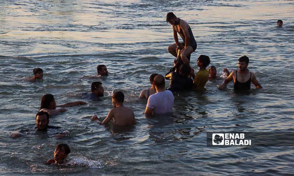 Young men in the Euphrates River in the countryside of Deir Ezzor, eastern Syria - July 20, 2024 (Enab Baladi/Obadah al-Sheikh)