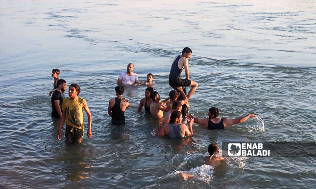 Young men in the Euphrates River in the countryside of Deir Ezzor, eastern Syria - July 20, 2024 (Enab Baladi/Obadah al-Sheikh)