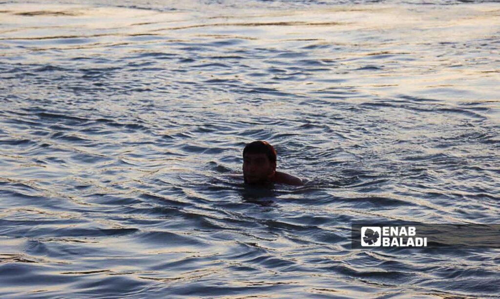 A young man swims in the Euphrates River in the countryside of Deir Ezzor, eastern Syria - July 20, 2024 (Enab Baladi/Obadah al-Sheikh)