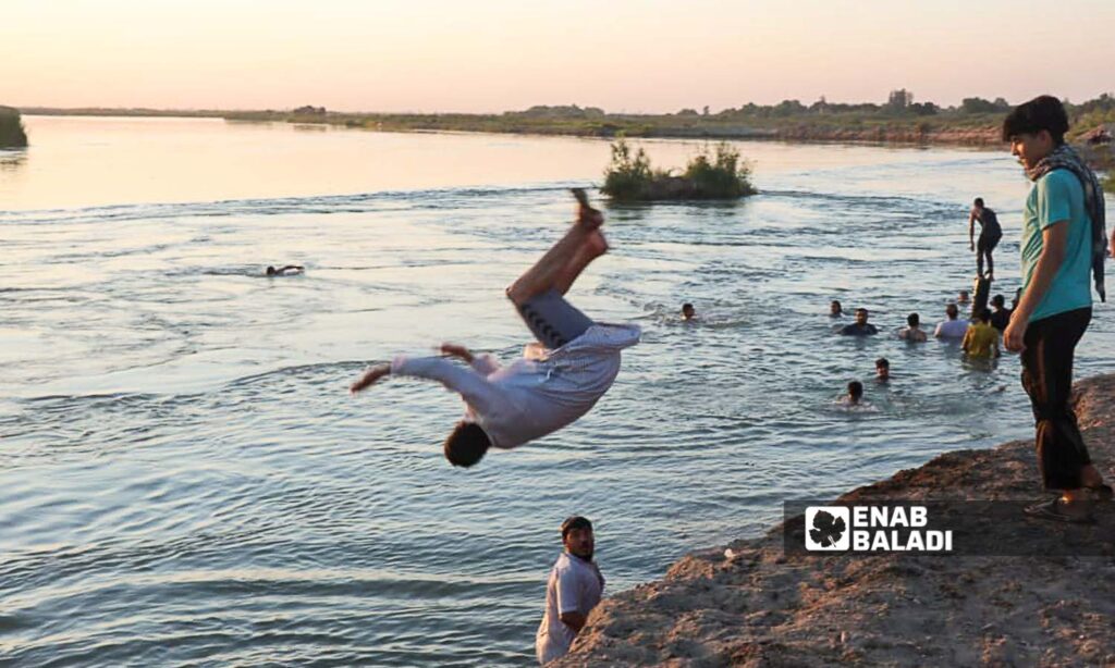 Young men swim in the Euphrates River in the countryside of Deir Ezzor, eastern Syria - July 20, 2024 (Enab Baladi/Obadah al-Sheikh)