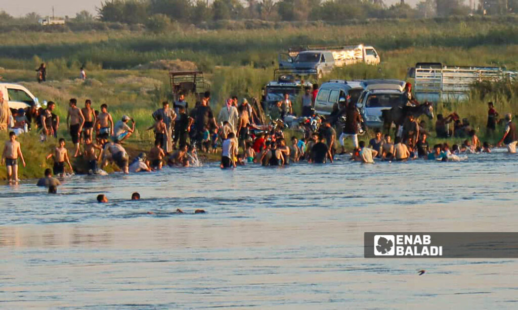 Young men on the banks of the Euphrates River in the area of al-Busayrah in the countryside of Deir Ezzor, eastern Syria - July 20, 2024 (Enab Baladi/Obadah al-Sheikh)