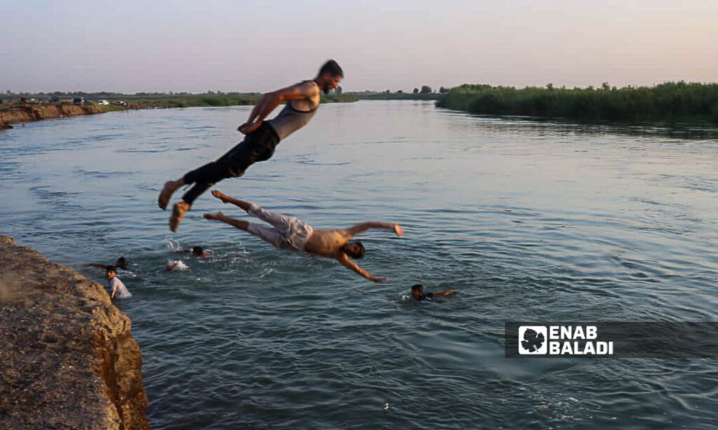 Young men swim in the Euphrates River in the countryside of Deir Ezzor, eastern Syria - July 20, 2024 (Enab Baladi/Obadah al-Sheikh)