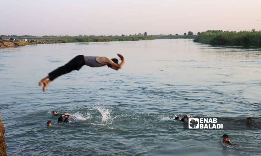 Young men swim in the Euphrates River in the countryside of Deir Ezzor, eastern Syria - July 20, 2024 (Enab Baladi/Obadah al-Sheikh)