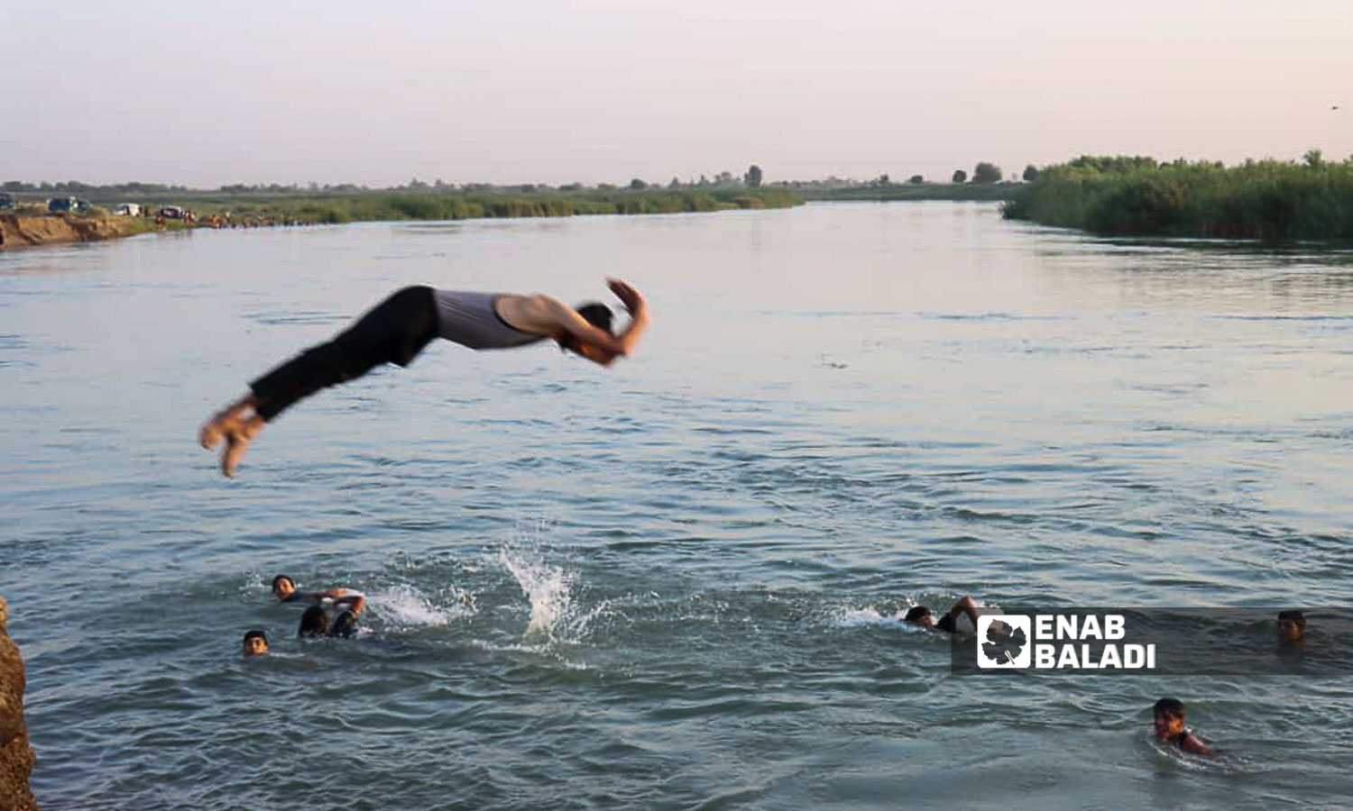 Young men swim in the Euphrates River in the countryside of Deir Ezzor, eastern Syria - July 20, 2024 (Enab Baladi/Obadah al-Sheikh)
