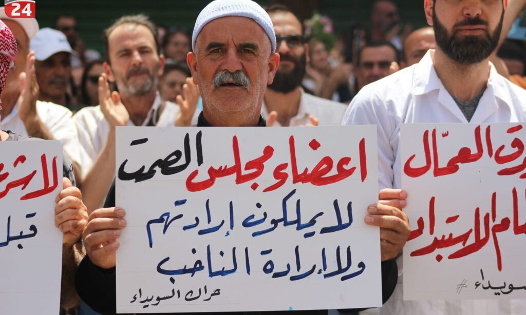 One of the banners raised by the protesters in the al-Karamah Square in As-Suwayda, calling for a boycott of the People's Assembly elections - July 5, 2024 (Suwayda 24)