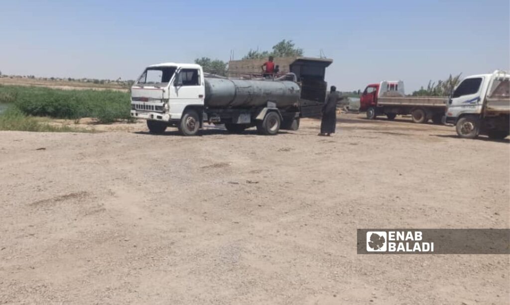 Water trucks being filled from a station in the town of al-Shannan, eastern Deir Ezzor governorate - July 7, 2024 (Enab Baladi/Obadah al-Sheikh)