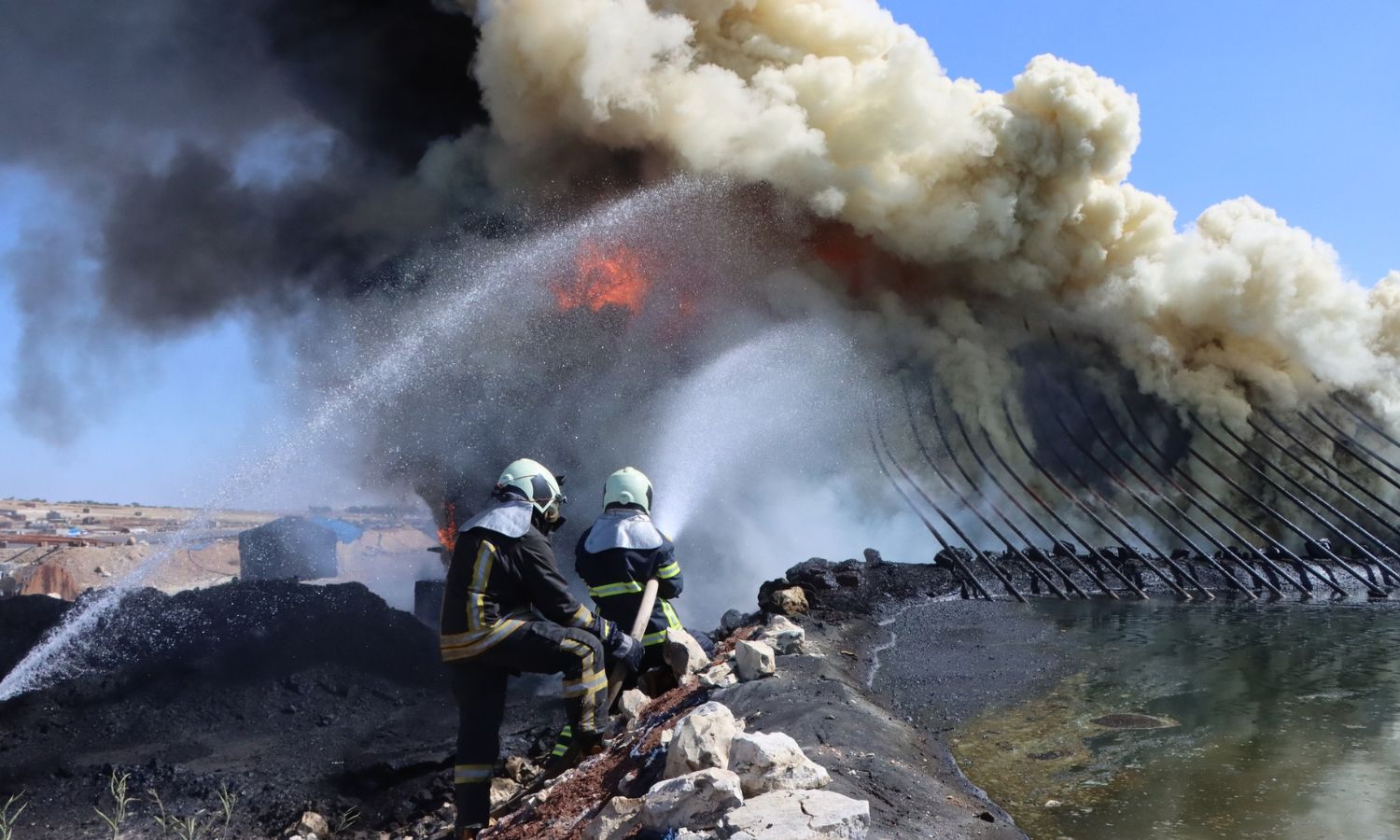 Elements of the Syria Civil Defence (White Helmets) extinguishing a fire in northwestern Syria - (Syria Civil Defence/Facebook)