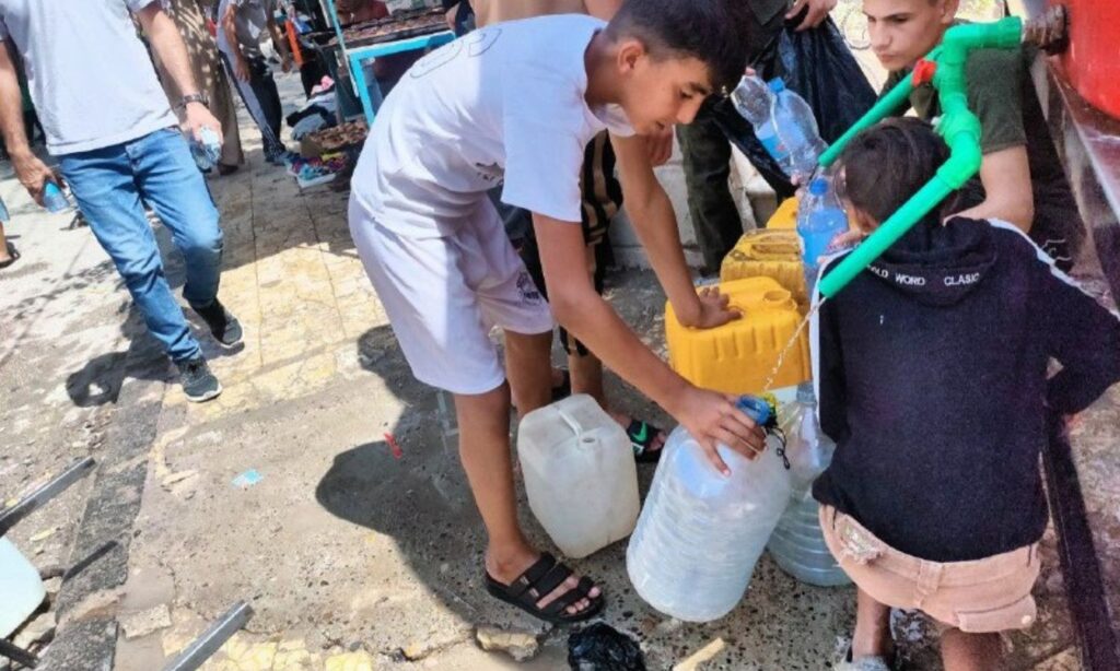 Children trying to fill water from a tank on Palestine Street in al-Hasakah - August 30, 2024 (Enab Baladi/Majd al-Salem)