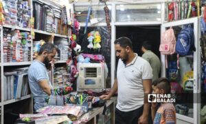 A father buys school supplies for his son in Ras al-Ain, northwest of al-Hasakah - September 9, 2024 (Enab Baladi)