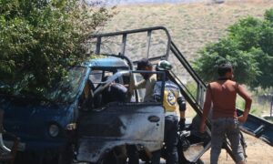 Civilians and civil defence members inspect a civilian car targeted by a suicide drone - August 6, 2024 (Syria Civil Defence/Facebook)