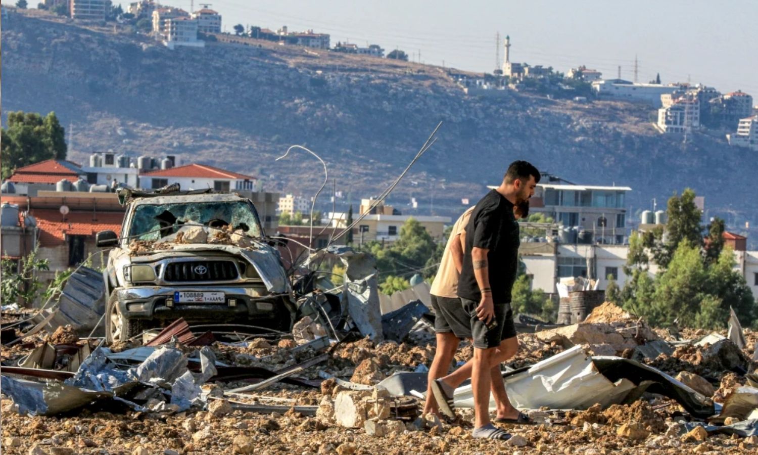 Young men inspect the site of an Israeli airstrike on the highway linking Beirut to the southern city of Sidon - September 25, 2024 (AFP)