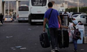 Syrians who were living in Lebanon and have returned to Syria due to the ongoing hostilities between Hezbollah and Israeli forces are carrying their belongings at the Jdeidet Yabous border crossing - September 25, 2024 (Reuters/Yamam al-Shaar)