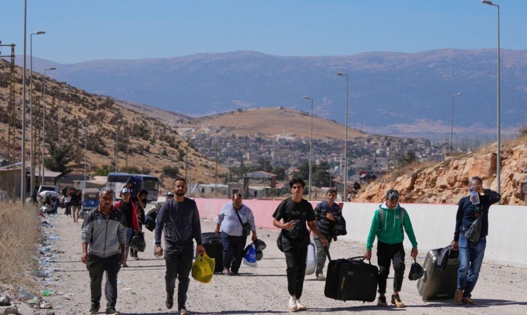 Displaced persons from Lebanon to Syria continue their journey on foot following Israel's bombing of the al-Masnaa crossing - October 4, 2024 (AP)