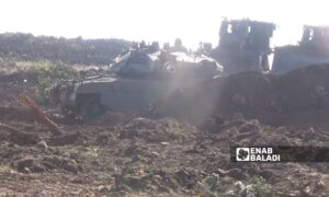 An Israeli Merkava tank secures protection for a military bulldozer during the clearing of agricultural land in southern Quneitra near the occupied Syrian Golan - September 9, 2024 (Enab Baladi/Zain al-Joulani)
