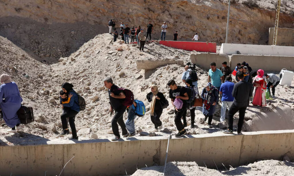 Syrians and Lebanese crossing the border at the Masnaa crossing after it was bombed - October 4, 2024 (Reuters)