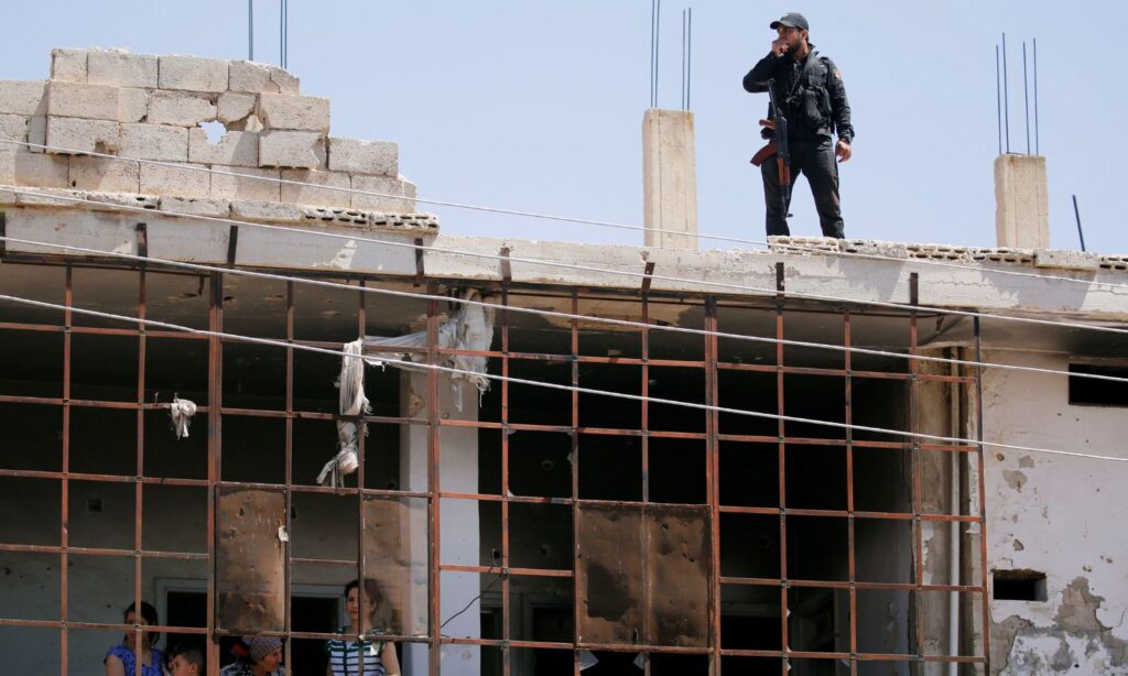 A soldier in the Syrian regime forces stands on the rooftop of a building in al-Qusayr during the return of some of the city's residents - July 7, 2019 (Reuters)