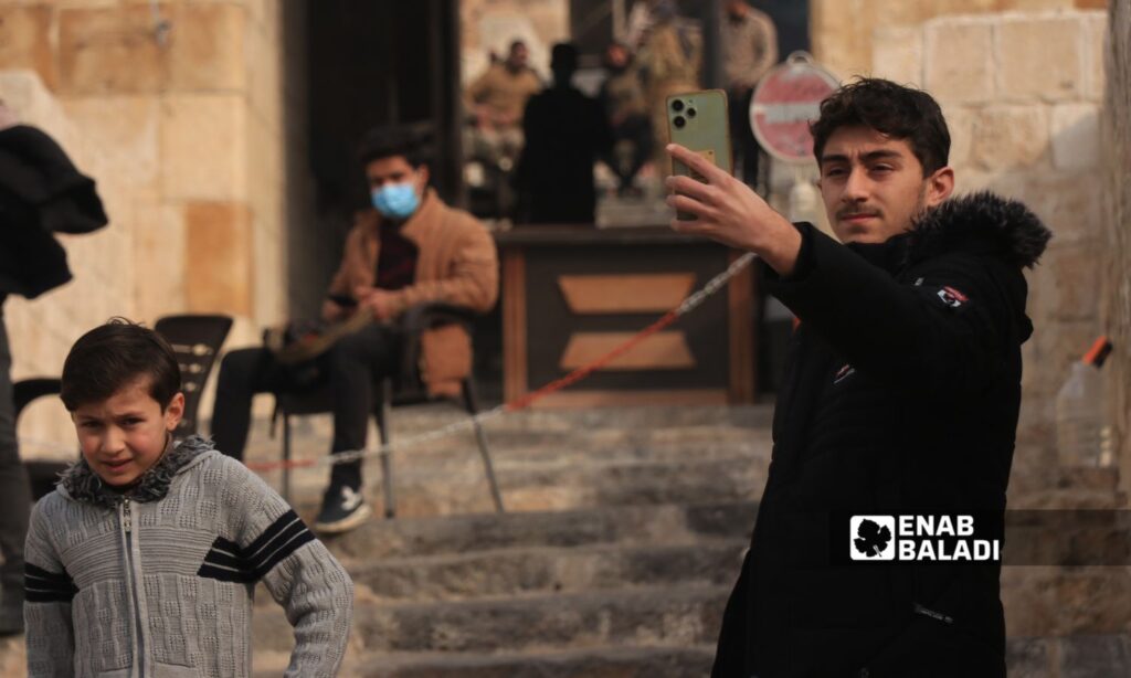 A young man takes a selfie near the historic Aleppo Citadel - December 12, 2024 (Enab Baladi/Walid al-Idlibi)