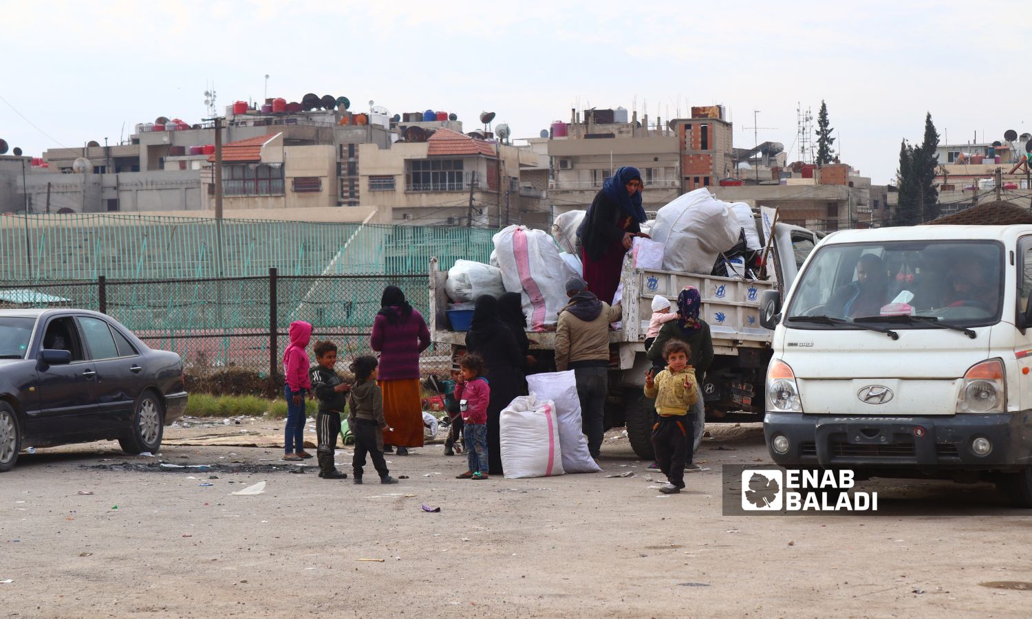 Dozens of families gather at the Martyrs of March 12 stadium in Qamishli city, northeast Syria - December 11, 2024 (Enab Baladi/Ruba Abbas)