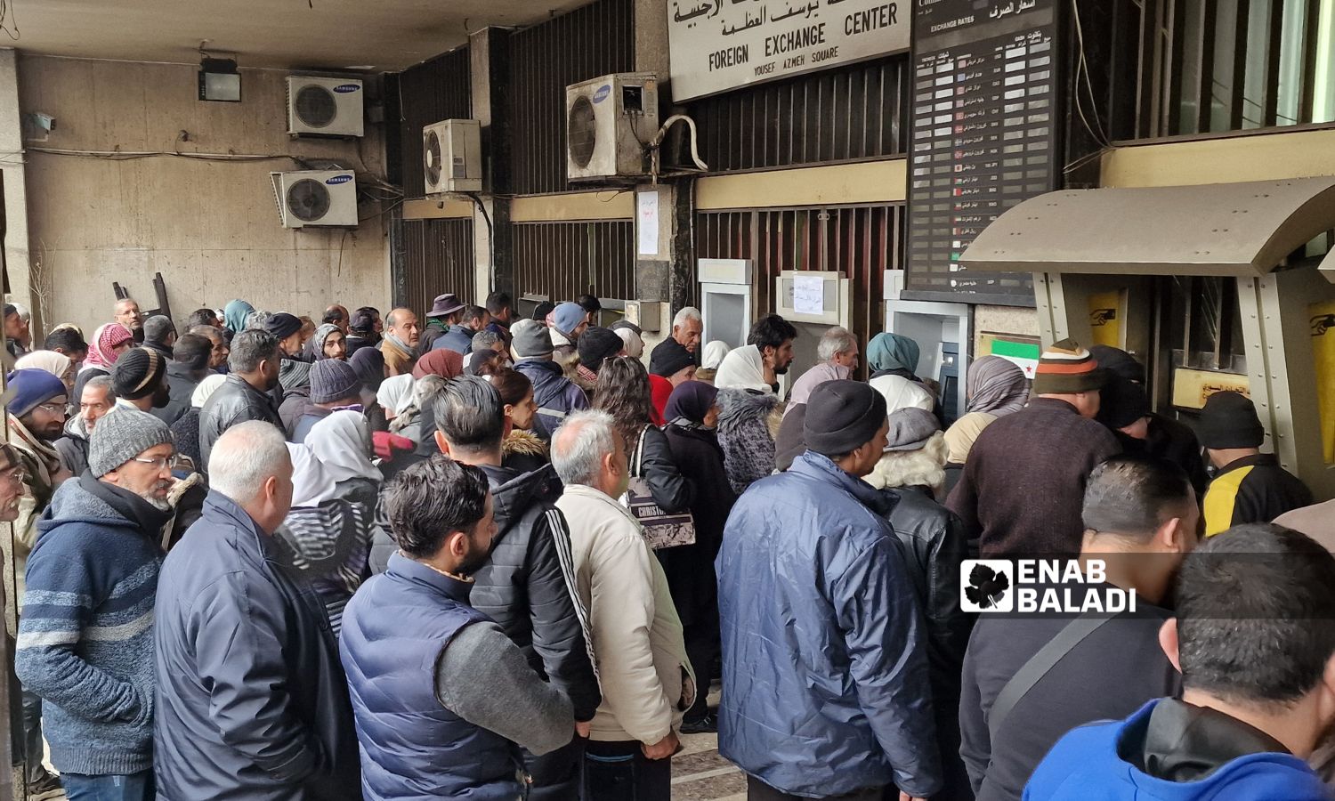 Employees waiting in line to withdraw their salaries from ATMs in Damascus - December 2024 (Enab Baladi/Anas al-Khouli)