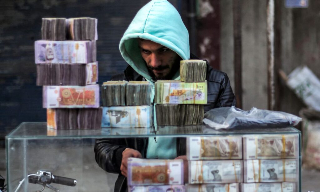 A currency trader in a market in Manbij, Aleppo province, northern Syria - January 4, 2025 (AFP)