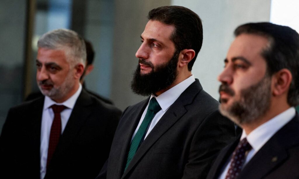 Syrian transitional president Ahmed al-Sharaa between the Ministers of Foreign Affairs and Interior - December 23, 2024 (Reuters)