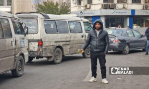 A young man selling foreign currencies on the streets of Damascus - March 15, 2025 (Enab Baladi/Anas al-Khouli)