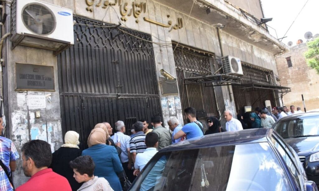 Citizens waiting in front of the Commercial Bank of Syria branch in Aleppo (Jamahir newspaper)