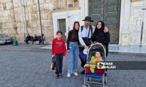 Rizkar Mahmoud Hassan with his family before starting his pilgrimage journey, at the Umayyad Mosque in Damascus - April 25, 2025 (Enab Baladi/Anas al-Khouli)