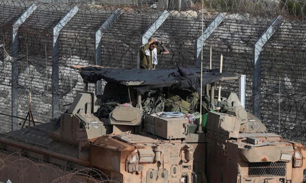 An Israeli soldier stands at the fence separating the Golan Heights from Syrian territory – January 10, 2025 (Reuters)