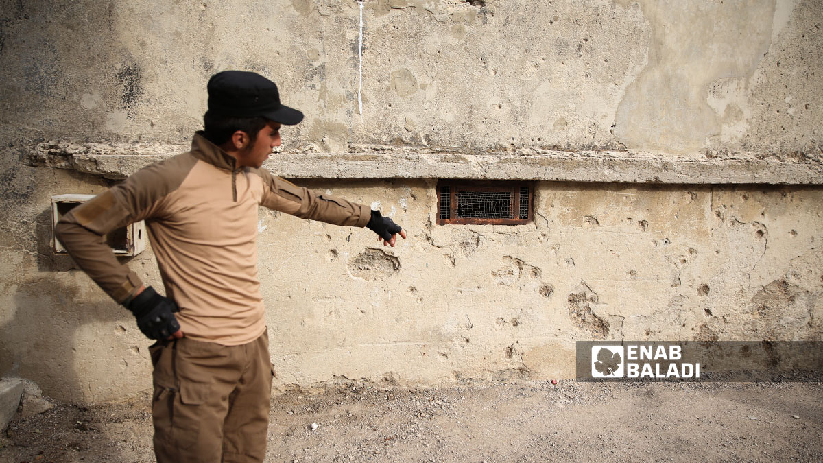 A young man points to bullet marks left by Israeli army fire in the town of Beit Jinn (southwestern rural Damascus, near the occupied Syrian Golan Heights), (Enab Baladi/Noor Hamza)