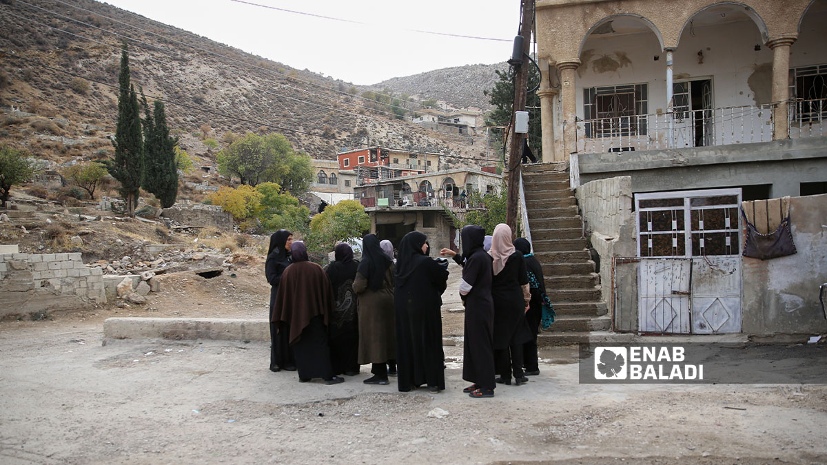 Syrian women gather with their neighbors to check on each other following a military operation carried out by the Israeli army in the town of Beit Jinn (southwestern rural Damascus, near the occupied Syrian Golan Heights), (Enab Baladi/Noor Hamza)