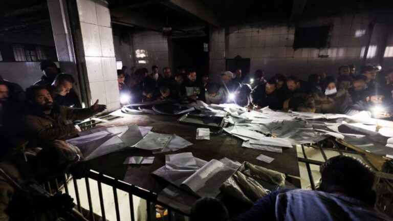 People search through documents as they join members of the Syrian Civil Defense group to look for prisoners underground in Saydnaya prison, 9 December 2024 (Reuters/Amr Abdallah Dalsh)