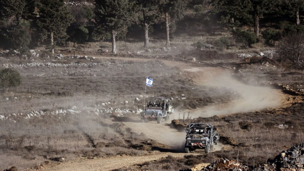 Two Israeli military vehicles pass through the ceasefire line separating the occupied Golan Heights and Syria in the Golan Heights, December 15, 2024. (Reuters)